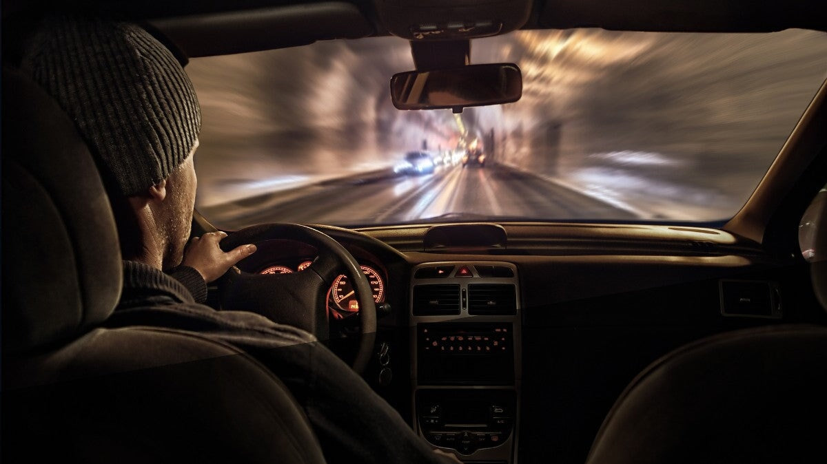 un homme conduisant une voiture dans la nuit