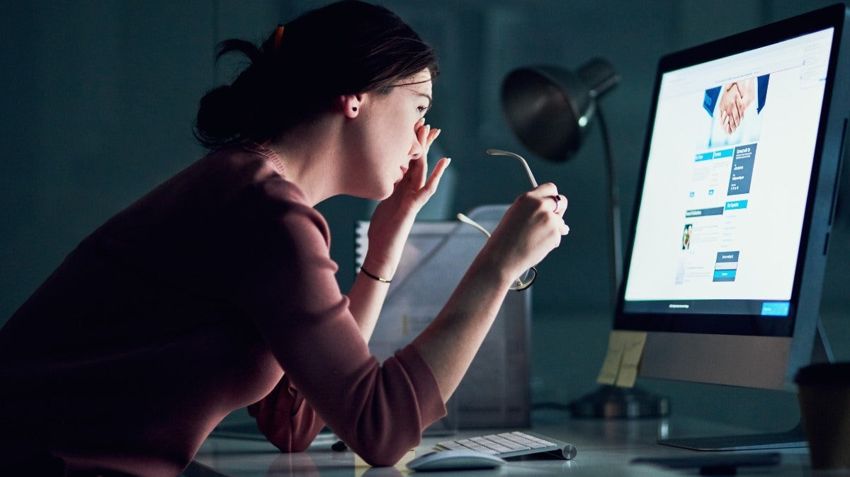 une femme souffrant de fatigue oculaire numérique due à trop de temps passé devant un écran