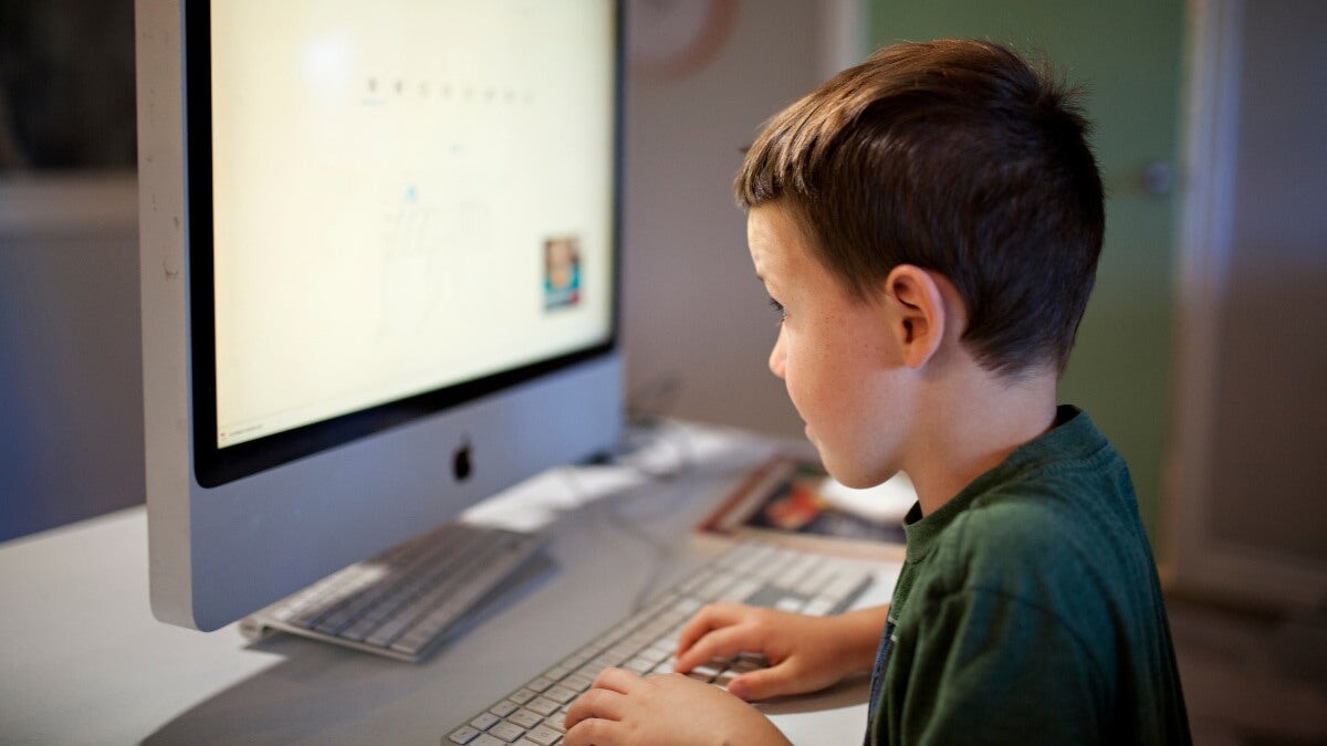 un petit garçon utilisant un ordinateur
