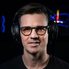 Notre cofondateur Matthieu porte les lunettes gamer urban revolution avec verre clair et un casque audio sur fond noir de face